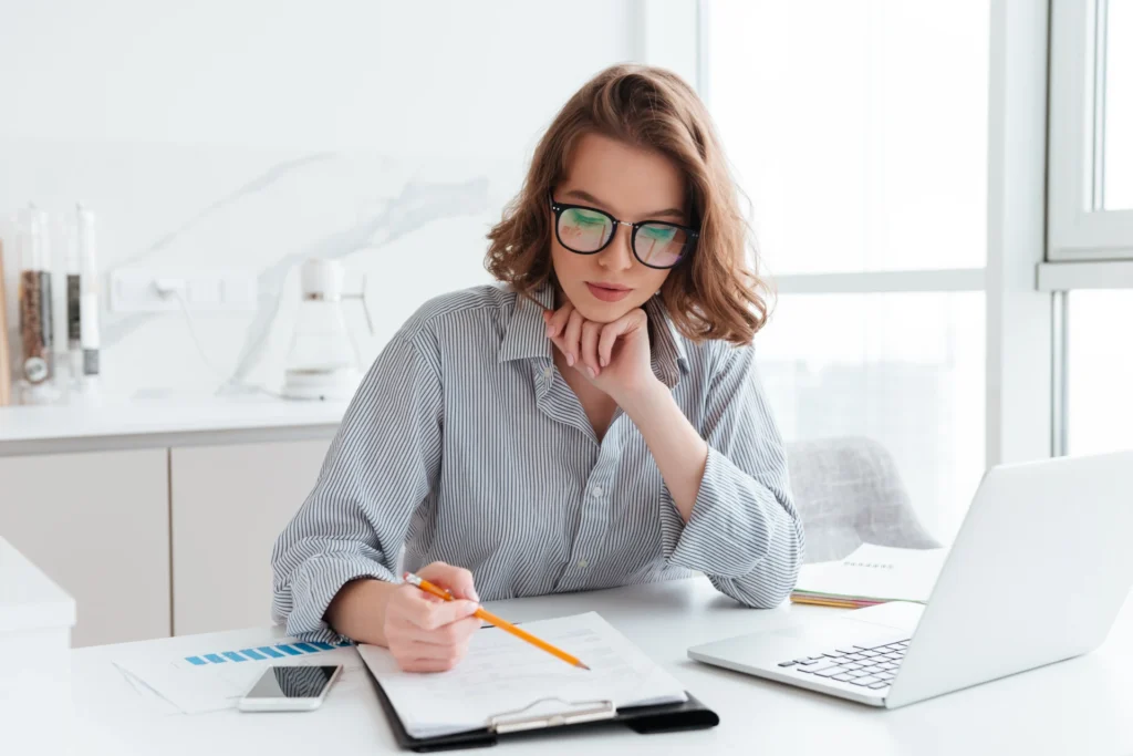 young-concentrated-tax-accountant-glasses-striped-shirt-working-with-papers